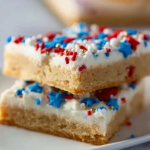 Patriotic sugar cookie bars decorated with red, white, and blue sprinkles.
