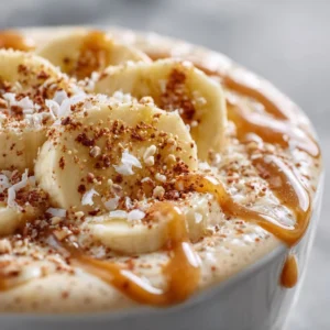 Delicious Apple Banana Smoothie garnished with fruit on a wooden table